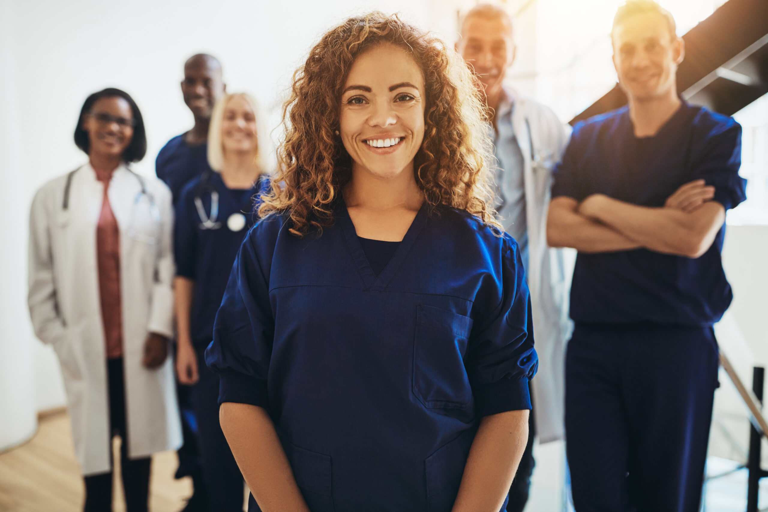 Smiling female doctor standing with medical colleagues