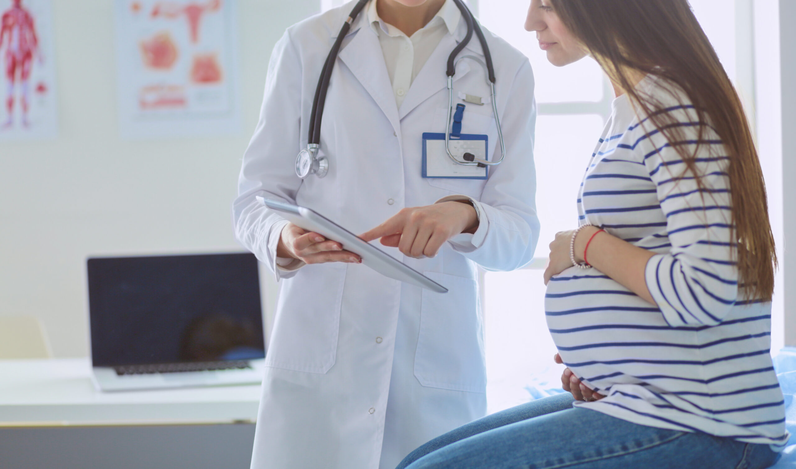 Smiling pregnant woman with the doctor at hospital